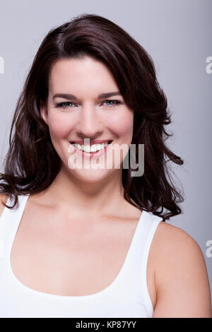 Attraente ridere giovane donna con lunghi capelli scuri Foto Stock