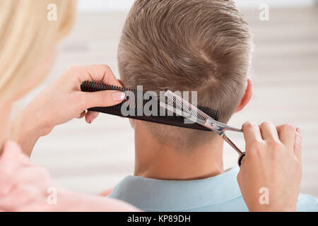 L'uomo Getting taglio di capelli da parrucchiere femmina a Salon Foto Stock