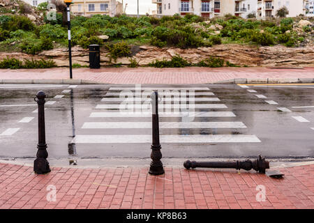 Bollard rotto in corrispondenza di un incrocio di zebra. Foto Stock