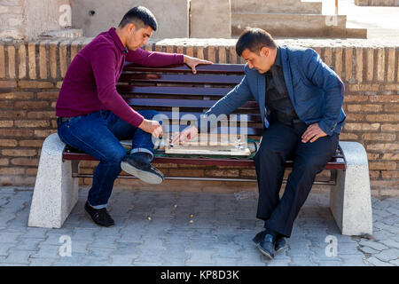 Due gli uomini uzbeki giocare ai giochi in strada, Khiva, Uzbekistan Foto Stock