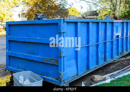 I cassonetti pieni con contenitore di rifiuti oltre che scorre Foto Stock