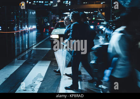 Salarymen per raggiungere a piedi la stazione di notte dopo la pioggia in Shibuya, Tokyo, Giappone Foto Stock
