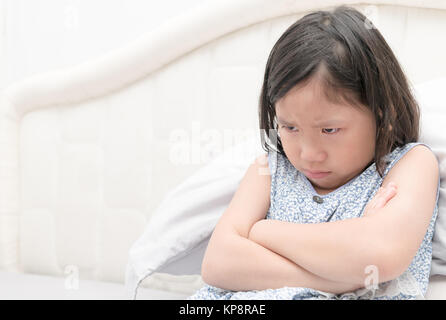 Arrabbiato e triste ragazza seduta sul letto, segno e gesto concept Foto Stock