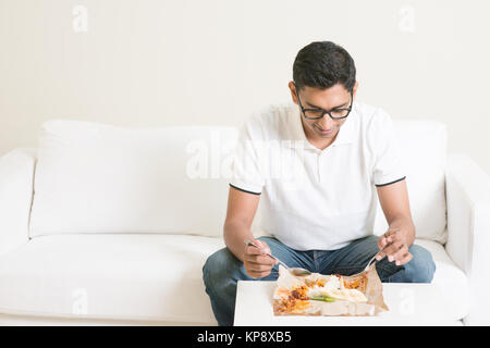 Lonely singolo uomo a mangiare cibo da soli a casa Foto Stock