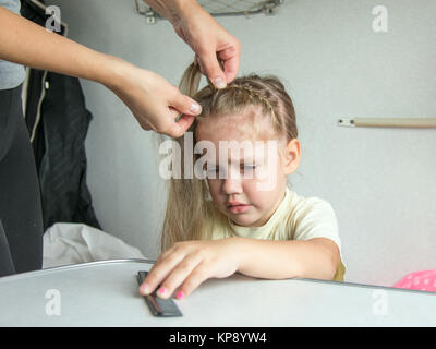 Quattro anni di ragazza grida di dolore quando mia madre pettinare i capelli Foto Stock