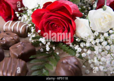 Una rosa rossa e dolci Foto Stock