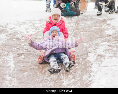 Due ragazze allegro cavalcare un roller coaster di ghiaccio Foto Stock