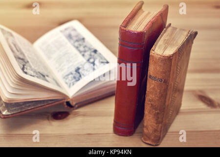 Antico messale. Massa di vecchi libri con copertina in pelle su tavola in legno rustico. Foto Stock