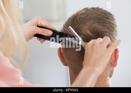 L'uomo Getting taglio di capelli da parrucchiere femmina a Salon Foto Stock