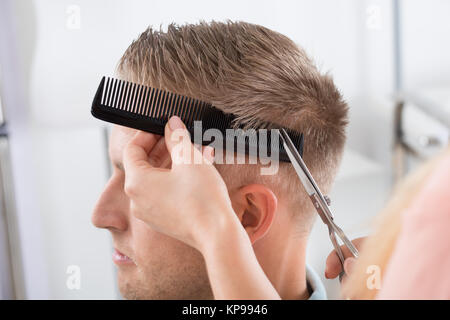 L'uomo Getting taglio di capelli da parrucchiere a Salon Foto Stock