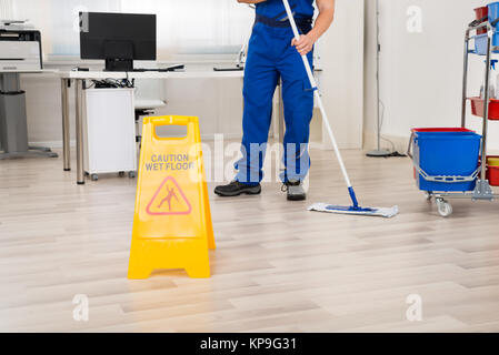 Pulizia bidello di piano con Mop in ufficio Foto Stock