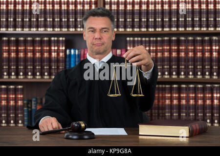 Giudicare tenendo la giustizia scala a tavola in aula Foto Stock