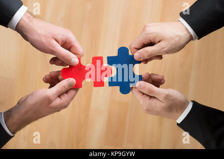 Immagine ritagliata di uomini di affari di assemblaggio di Puzzle Foto Stock