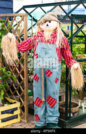 Un classico spaventapasseri dotato di un display di giardinaggio in un giardino inglese centro nel WILTSHIRE REGNO UNITO Foto Stock