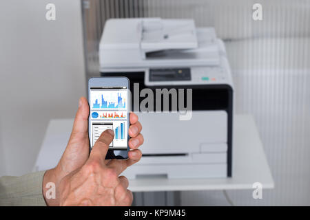 Imprenditore dando il comando Stampa sullo smartphone Foto Stock