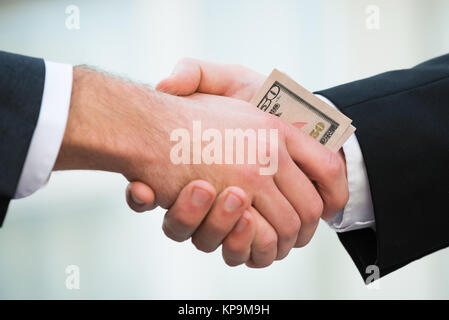 Imprenditore Partner corrompete agitando a mano Foto Stock