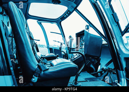 Elicottero cabina interna, vista laterale del sedile e del cruscotto. Heli sul terreno. Colorate in blu Foto Stock