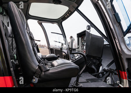 Elicottero cabina interna, vista laterale del sedile e del cruscotto. Heli sul terreno. Foto Stock