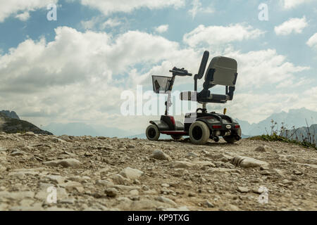 Sedia a rotelle motorizzata per persone monouso, Mobile buggy elettrico sulla montagna, Dolomiti, Italia. Disattivare auto Foto Stock