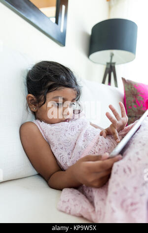 Ragazza indiana con la compressa a casa Foto Stock