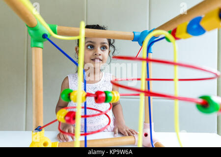 Indian bambina gioca il legno cordone cablate loop Foto Stock