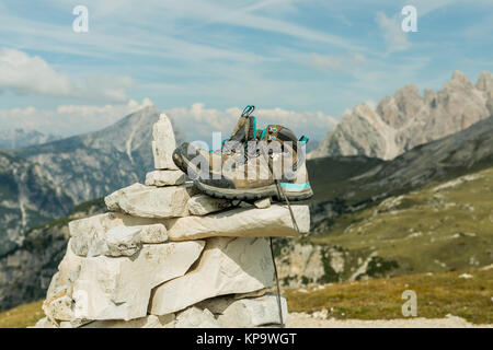 Scarponi da montagna per escursionismo sullo sfondo delle Dolomiti regione Tre Cimme, Italia. Scarpe da trekking di un escursionista su una roccia in montagna. Foto Stock