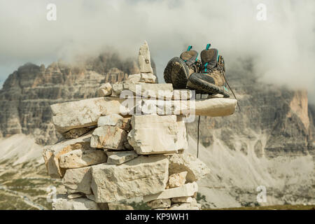 Scarponi da montagna per escursionismo sullo sfondo delle Dolomiti regione Tre Cimme, Italia. Scarpe da trekking di un escursionista su una roccia in montagna. Foto Stock