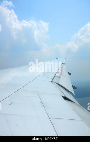 Ala di aeroplano che vola sopra le nuvole con bel cielo Foto Stock