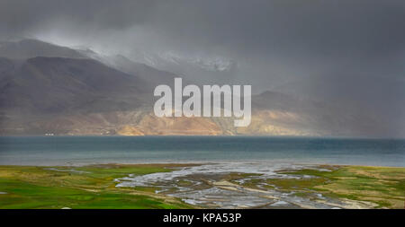 Tempesta sul Lago di Tso Moriri: blu di superficie del lago, green river floodplain, montagne sono persi in nubi e nebbia, Ladakh, India. Foto Stock