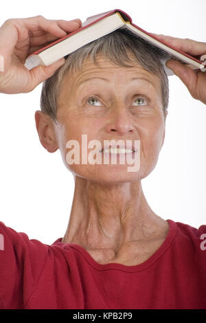 Modello di rilascio, Frau, 60+, mit Buch am Kopf - donna, 60 + , con libro sulla testa Foto Stock