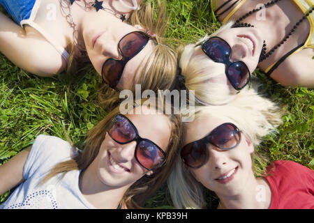 Modello di rilascio, Symbolbild Freundeskreis, Jugendliche Maedchen liegen Kopf un Kopf in der Wiese - simbolico per un circolo di amici Foto Stock