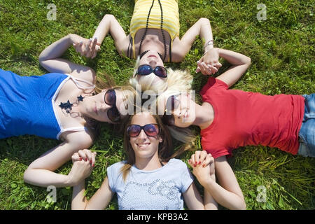 Modello di rilascio, Symbolbild Freundeskreis, Jugendliche Maedchen liegen Kopf un Kopf in der Wiese - simbolico per un circolo di amici Foto Stock