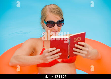 Modello di rilascio, Junge Frau beim Lesen im Swimmingpool - donna lettura in piscina Foto Stock