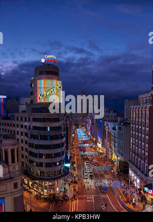 Vista del tramonto di Gran Via illuminata da luci di Natale e cartelli di segnalazione al neon si trova nel centro di Madrid. Vista dalla Piazza Callao. Spagna. Foto Stock