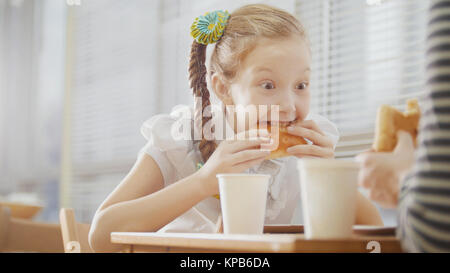 Ragazza con spiralina è mangiare dolci in cafe Foto Stock