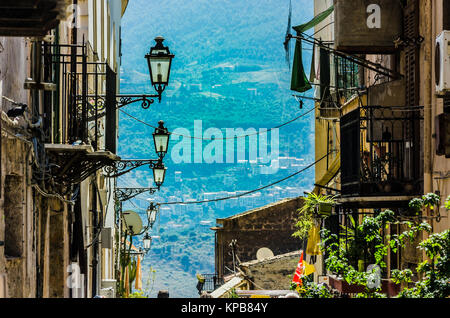 Strada in salita con lampioni e vecchie costruzioni con i loro balconi nella città di monreale vicino a palermo sicilia Foto Stock