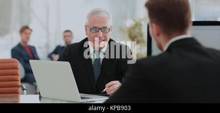 Business Partner per discutere in sala riunioni con il loro collega Foto Stock