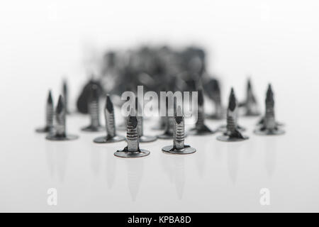 Un mucchio di feltro chiodi con i punti che mostra su uno sfondo bianco possibile concetto di utilizzo. Foto Stock