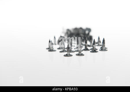 Un mucchio di feltro chiodi con i punti che mostra su uno sfondo bianco possibile concetto di utilizzo. Foto Stock