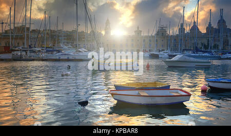 Marina in Vittoriosa, una delle tre città in tutta la baia di La Valletta, Malta. Sunrise attraverso le nuvole sopra il Museo Marittimo di costruzione Foto Stock