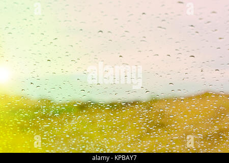 Gocce d'acqua sul vetro contro il tramonto sullo sfondo Foto Stock