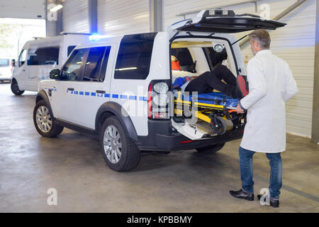 I paramedici offload della paziente da un'ambulanza Foto Stock