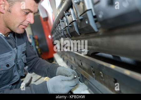 Dipendente della fabbrica lavorando sulla linea Foto Stock