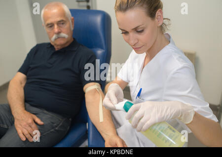 Preparazione per il test del sangue con la bella bionda e giovane medico Foto Stock