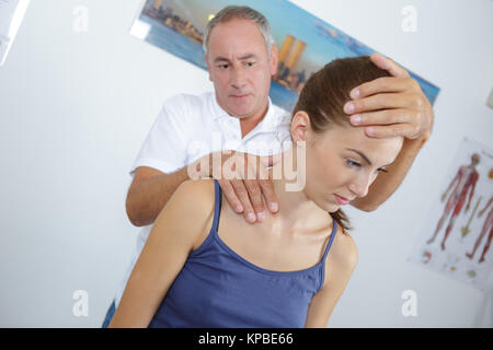 Osteopata lavorando sulle spalle del paziente Foto Stock