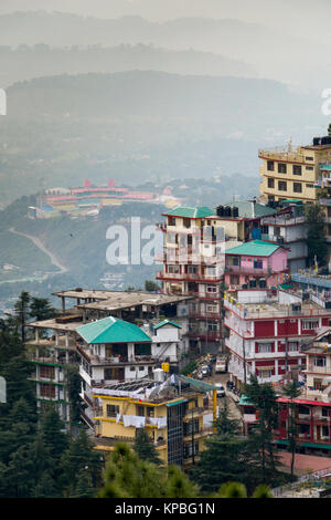 Gli alberghi e gli appartamenti su una collina in Mcleod Ganj con Himachal Pradesh Associazione Cricket Stadium di Dharamshala al di sotto di Foto Stock