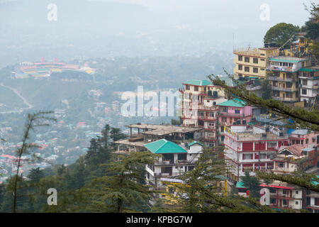 Gli alberghi e gli appartamenti su una collina in Mcleod Ganj con Himachal Pradesh Associazione Cricket Stadium di Dharamshala al di sotto di Foto Stock