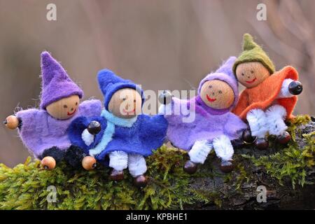 Quattro gnomi piccoli si siedono nel muschio Foto Stock