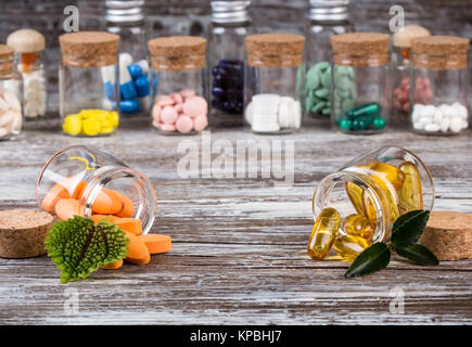 Medicine alternative con foglie verdi in contenitori in vetro Foto Stock