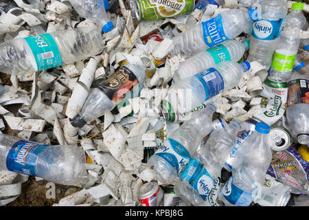 Le bottiglie di plastica, lattine di alluminio e di altri rifiuti in pila sul terreno Foto Stock